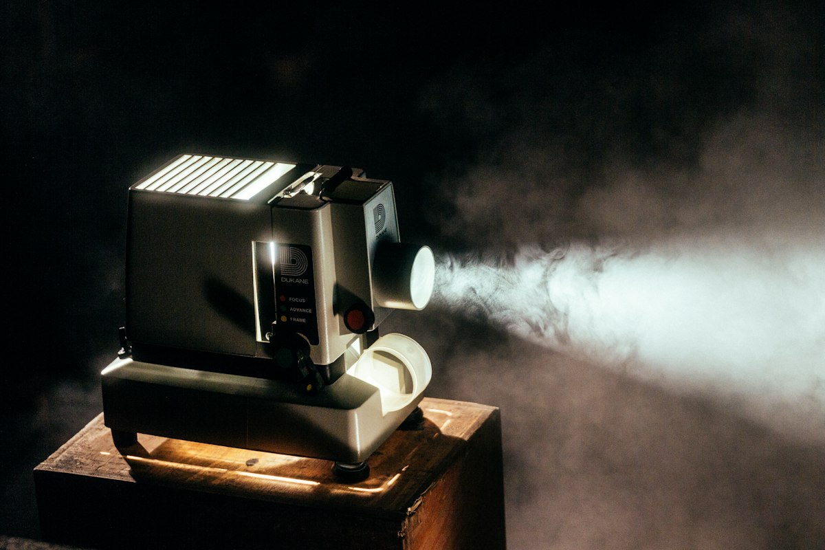 Proyector cinematográfico transmitiendo una película en la oscuridad